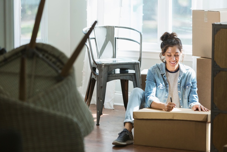 woman making a plan while packing boxes and moving