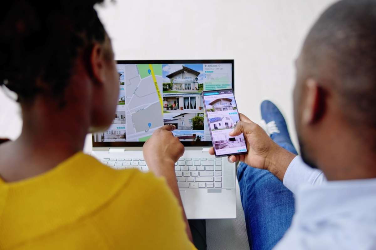 A couple looking at property listings together on a phone