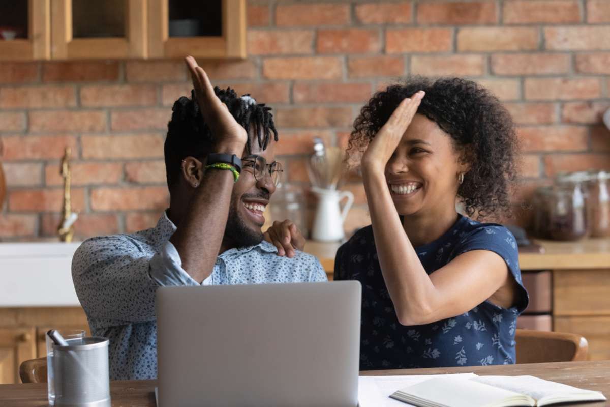 Happy and excited couple celebrating at a laptop, happy tenants concept